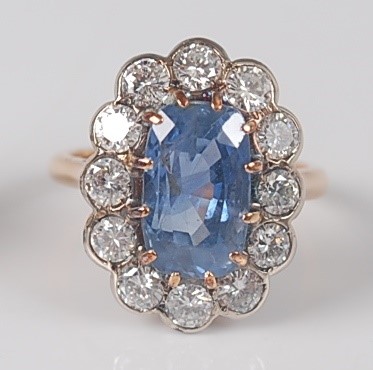 Lot 1174 - A sapphire and diamond oval cluster ring, claw...