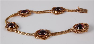 Lot 1176 - A yellow metal and cabochon garnet set...