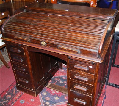 Lot 1293 - An early 20th century walnut roll top kneehole...
