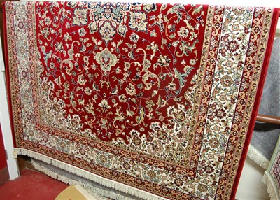 Lot 1145 - A machine-woven Persian woollen red ground...