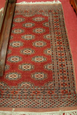 Lot 1139 - A Persian woollen red ground Bokhara rug, with...