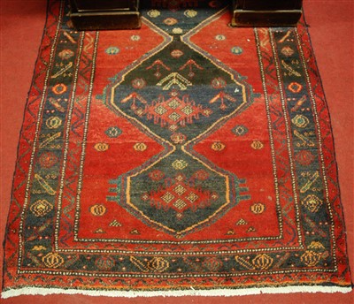 Lot 1141 - A Caucasian woollen red ground rug, having...