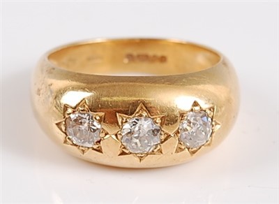 Lot 1192 - An 18ct yellow gold Gypsy style three stone...