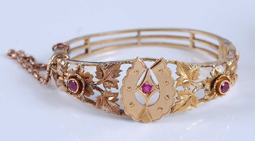 Lot 1194 - A late Victorian yellow metal hinged bangle,...