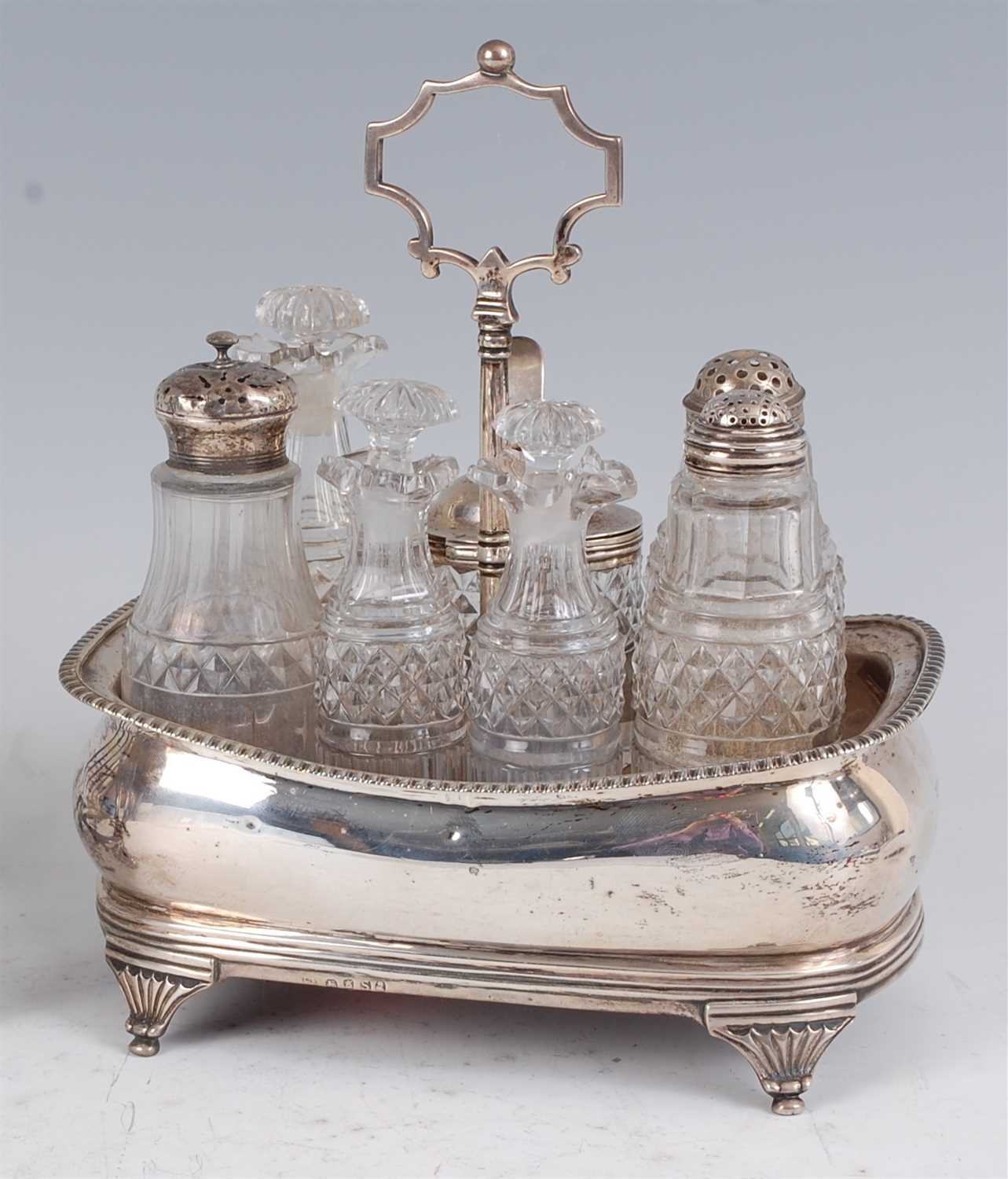 Lot 1141 - A George III silver seven bottle cruet stand,...