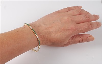 Lot 2646 - A yellow metal, emerald and diamond line...