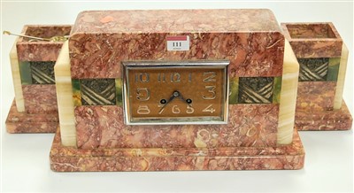 Lot 111 - An Art Deco rouge marble cased clock garniture,...
