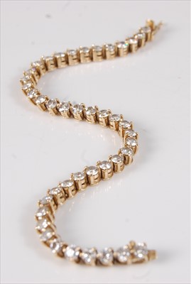 Lot 2207 - An 18ct yellow gold diamond tennis bracelet,...