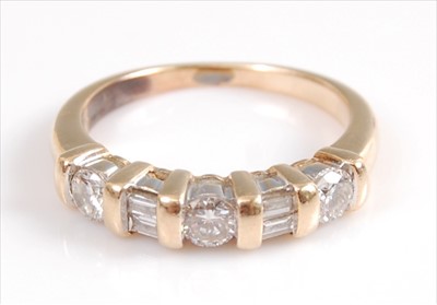 Lot 2053 - A yellow metal diamond seven stone half hoop...