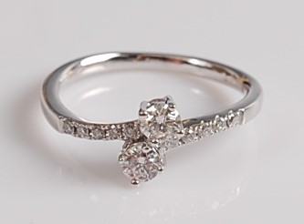 Lot 2076 - An 18ct white gold diamond two-stone crossover...