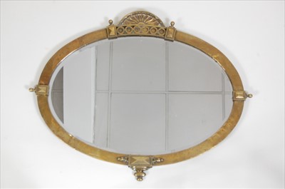 Lot 337 - An Art Deco brass framed bevelled oval wall...