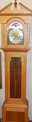 Lot 1130 - A contemporary light oak long case clock,...