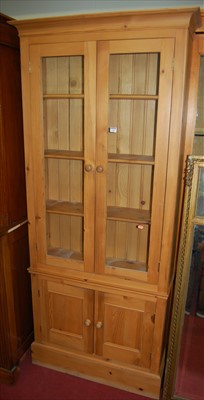 Lot 1165 - A modern pine freestanding bookcase cupboard,...