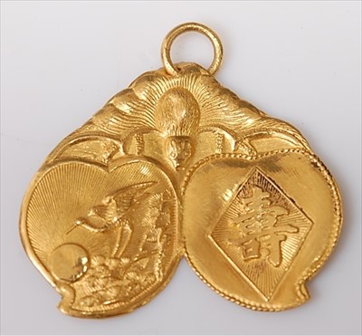 Lot 443 - A Chinese yellow metal pendant, embossed with...