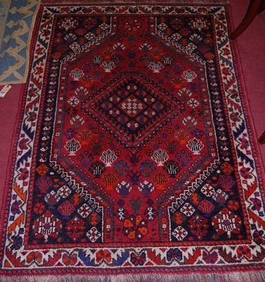 Lot 1181 - A Persian woollen red ground Shiraz rug, 156 x...