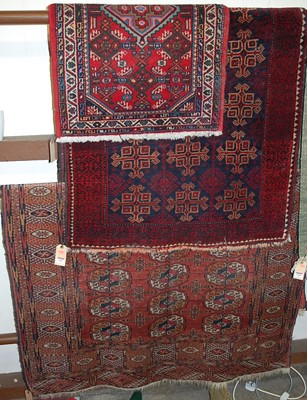 Lot 1187 - A Persian woollen red ground Bokhara rug;...