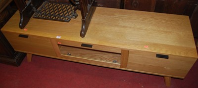 Lot 1404 - A contemporary light oak low media unit, w.150cm