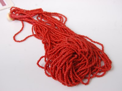 Lot 387 - A multi-strand fine 'coral' coloured bead...