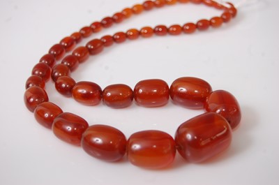 Lot 396 - A faux amber necklace, the graduated oval...