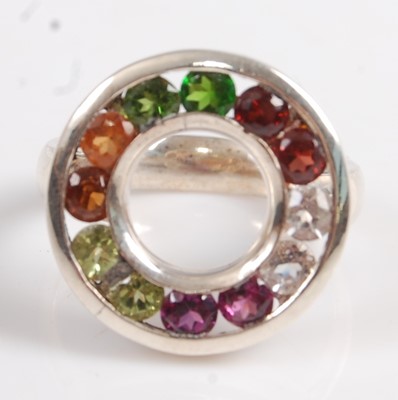 Lot 2574 - A white metal circular multi-stone ring,...