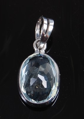 Lot 2590 - A white metal oval aquamarine pendant, the...