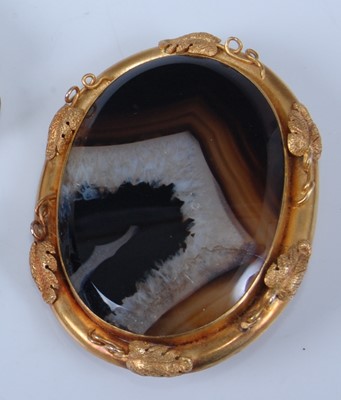 Lot 1233 - A yellow metal oval banded agate brooch,...