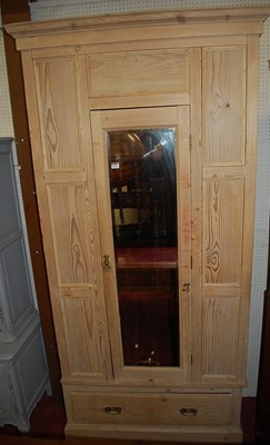 Lot 1118 - A pine single mirrored door wardrobe, having...