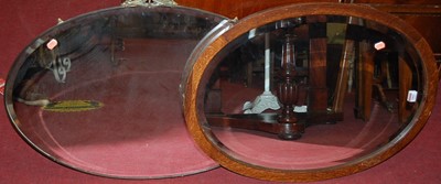 Lot 1062 - An oak framed and bevelled oval wall mirror...