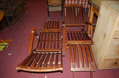 Lot 1278 - A pair of stained and slatted teak folding...