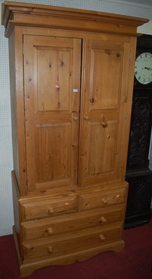 Lot 1121 - A modern pine double door wardrobe, the...