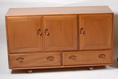 Lot 353 - An Ercol light elm three door sideboard,...