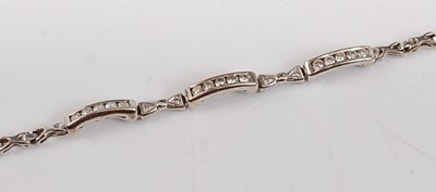Lot 2600 - A white metal diamond line bracelet, featuring...