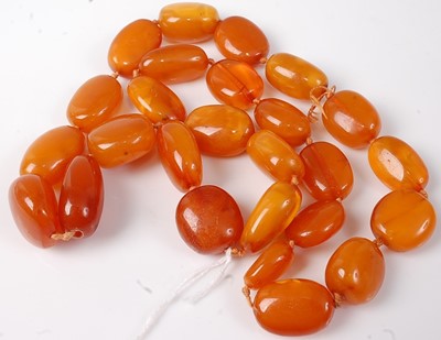 Lot 417 - A beaded faux amber knotted necklace, 111g,...