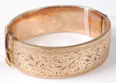 Lot 464 - A rolled gold and engraved hinged bangle, dia.7cm
