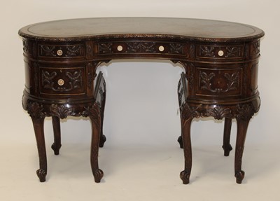 Lot 2511 - A carved walnut kidney shaped kneehole writing...