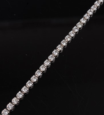 Lot 2216 - An 18ct white gold diamond tennis bracelet,...