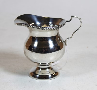 Lot 335 - A George V silver cream jug, having beaded...