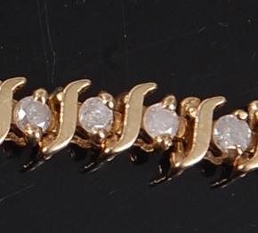 Lot 3110 - A yellow metal diamond line bracelet,...