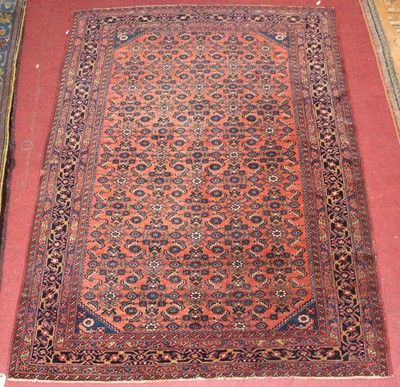Lot 22 - * A Persian woollen rug, the rust coloured...