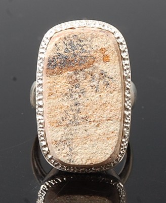 Lot 2576 - A white metal dress ring, featuring a rough...