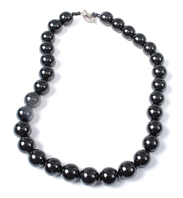 Lot 2601 - A single row necklace of thirty 13mm round...