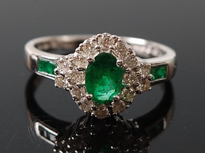 Lot 2616 - A white metal, emerald and diamond oval...