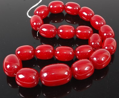 Lot 404 - A beaded faux cherry amber necklace, the...