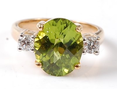 Lot 2711 - A yellow metal peridot and diamond three stone...