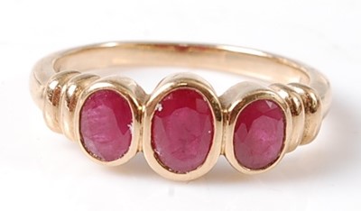 Lot 2730 - A 9ct yellow gold ruby three-stone ring,...