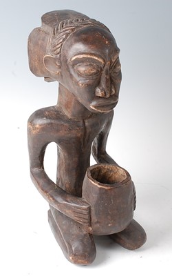 Lot 84 - * A carved wooden figure in kneeling pose with...