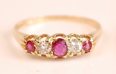 Lot 3098 - A yellow metal, ruby and diamond half hoop...