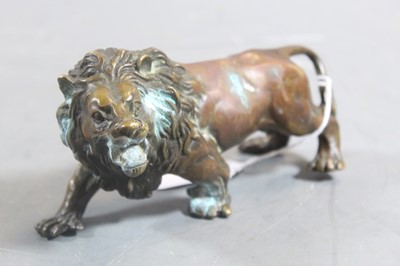 Lot 270 - A patinated bronze model of a prowling lion,...