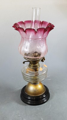 Lot 150 - A 19th century glass oil lamp, the cranberry...