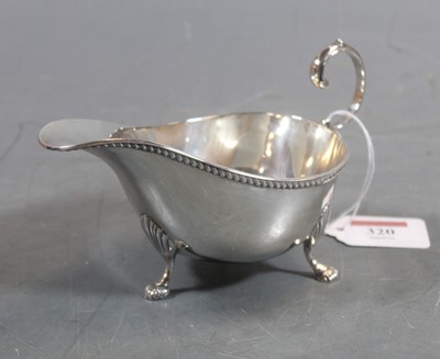 Lot 320 - A George V silver sauceboat, having a beaded...